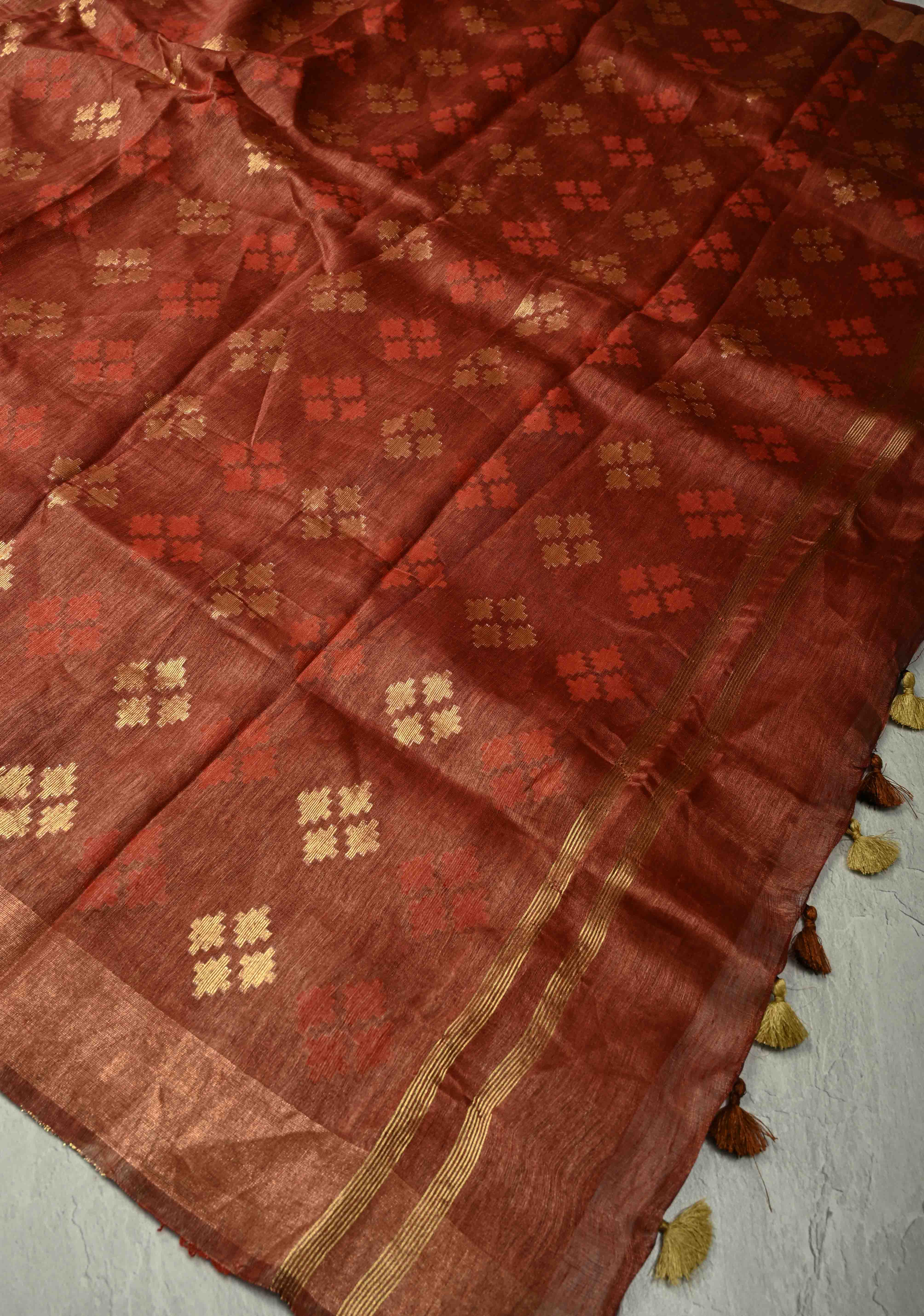 Copper Rust Silk Linen Saree with Muted Tissue Border and Floral Buttas on Pallu | Shobitam