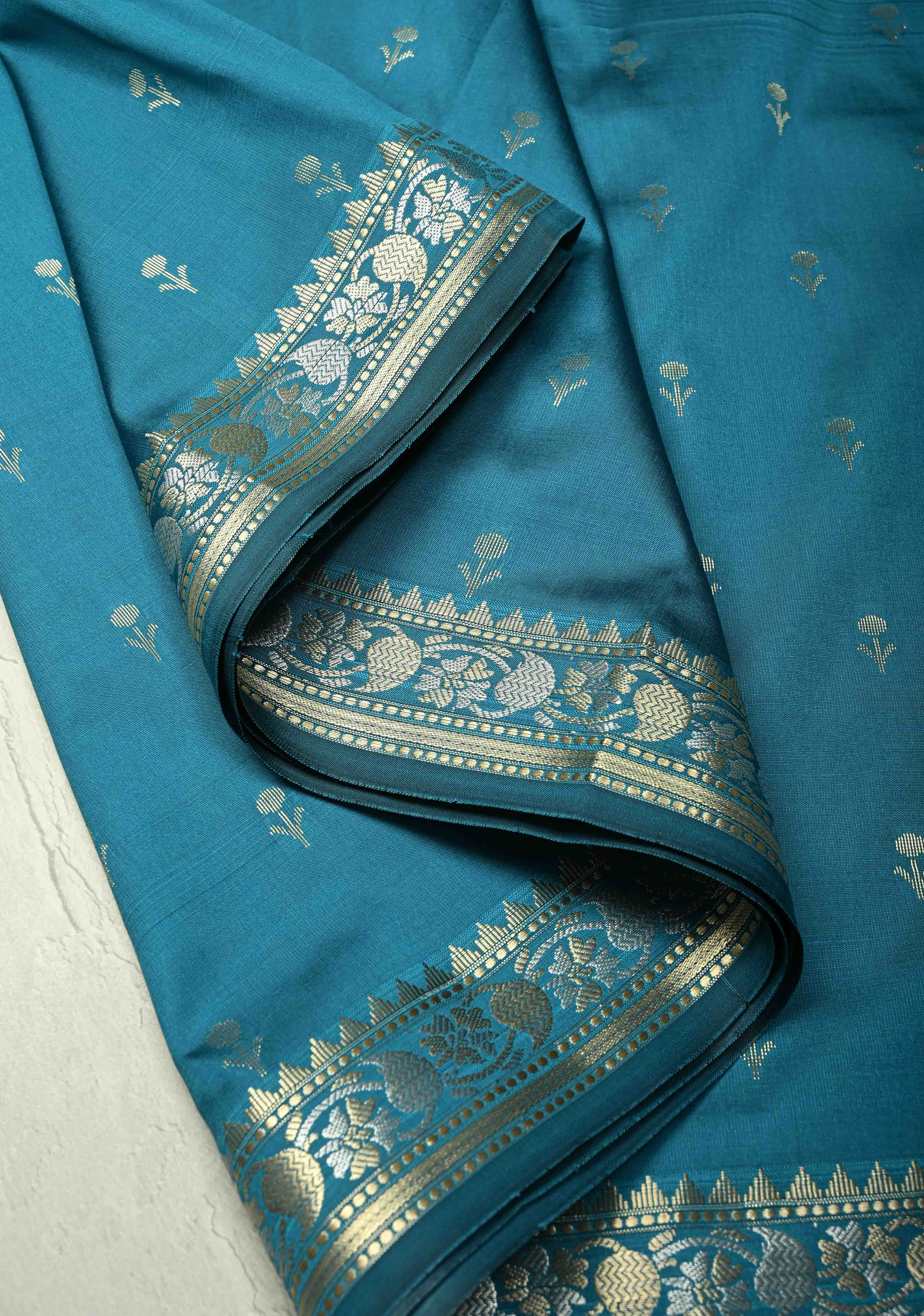 Peacock Blue Semi Silk Saree with Floral Buttis and Alfi Zari Border | Shobitam