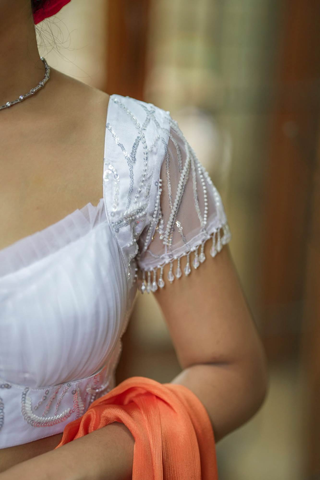 White sequin sweetheart neck blouse with net frills detailing.