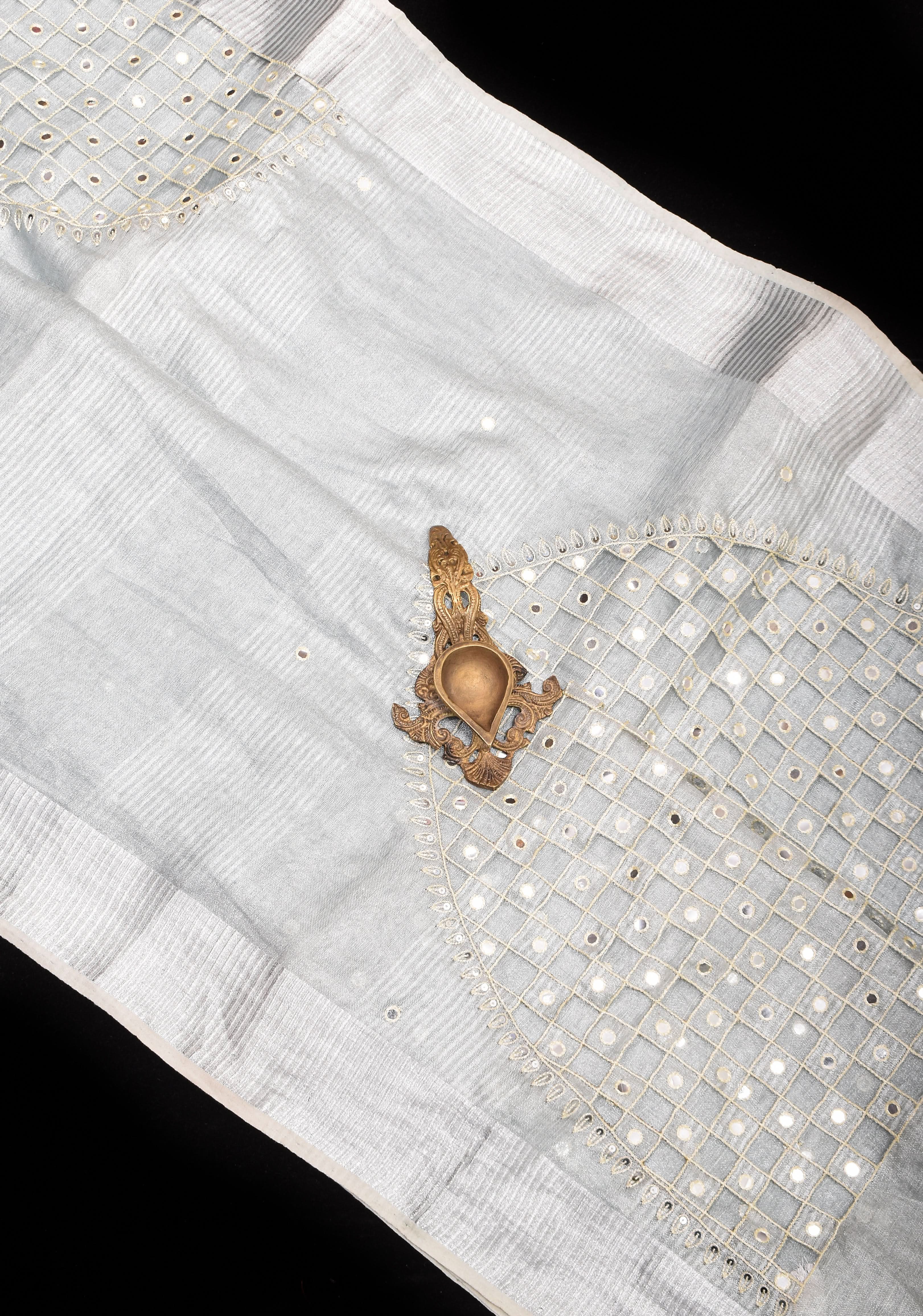 Cutwork and Mirror Work Tissue Linen Saree in White Silver with dramatic tassels | Shobitam