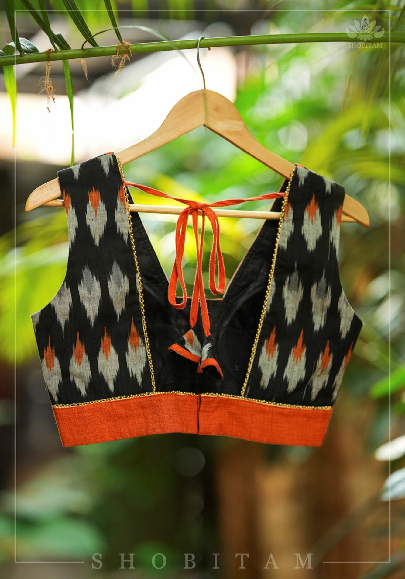 Black and orange cotton Ikkat square neck sleeveless blouse with orange handloom border.