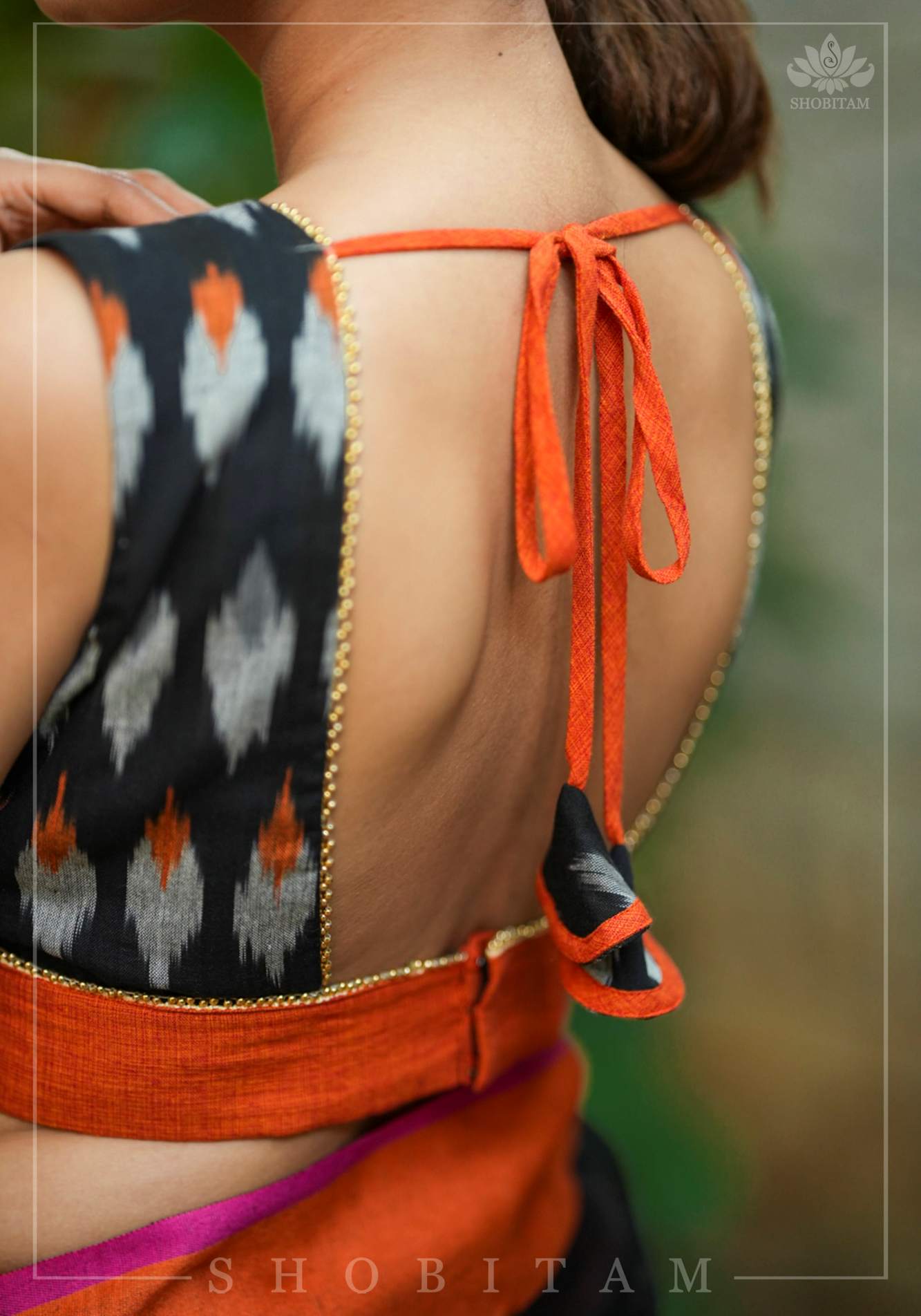 Black and orange cotton Ikkat square neck sleeveless blouse with orange handloom border.