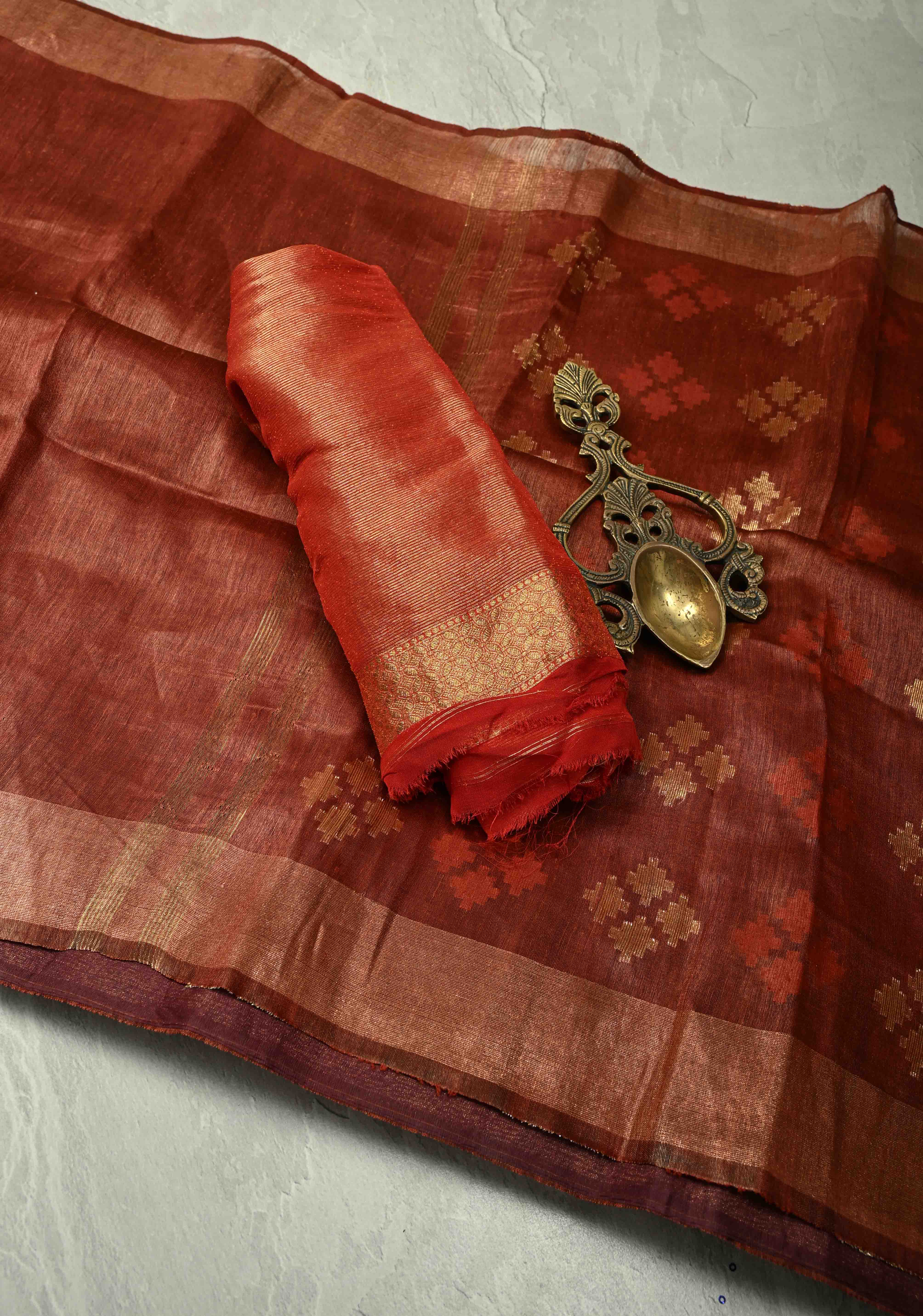 Copper Rust Silk Linen Saree with Muted Tissue Border and Floral Buttas on Pallu | Shobitam
